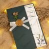 Close-up of watercolour olive branch design on cream wedding card