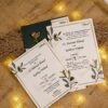 Complete botanical wedding card set with green envelope on burlap backdrop
