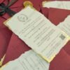 Burgundy wedding card with gold leaf edges styled with fairy lights