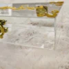 Close-up of gold hinges and clasp on clear acrylic box