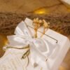 Close-up pearl drop ribbon and dried flowers on bid boxes