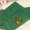 Clear acrylic nikkah card on dark green envelope showing event details