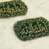 Close-up of gold kora Mashallah calligraphy on green velvet capsule Imam Zamin with crystal lattice border