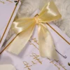 Pristine white Islamic favor cards adorned with gold satin bows