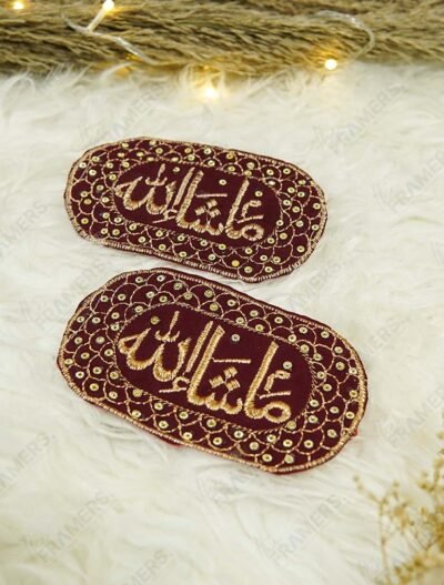 Close-up of gold Mashallah calligraphy on dark maroon velvet capsule Imam Zamin