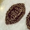 Matching pair of maroon Mashallah Imam Zamin armbands displayed on fur