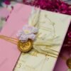 Close-up of gold foil calligraphy text on cream wedding card insert