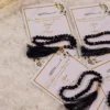 Close-up of custom Islamic favor card with black prayer beads