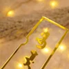 Close-up of 3D gold Arabic calligraphy on acrylic presentation holder