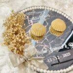 Mirror nikkah ring tray featuring velvet seashell ring boxes, golden bow, and pearl border