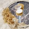 Detail of pearl border, golden satin bow, and dried baby's breath on nikkah ring tray