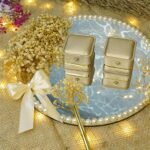 Top view of marble mirror ring tray with gold velvet ring boxes and pearl border