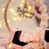Pink and rose gold engagement ring platter with floral hoop, "The Beginning of Forever" sign, and pink LED ring boxes