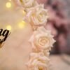 Close-up of pink velvet LED ring box and blush roses on floral hoop ring tray