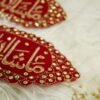 Detail of golden scalloped border with sparkling stones on red velvet Nikkah armband