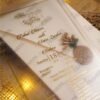 Multiple vellum wedding cards with gold wax seals arranged on jute