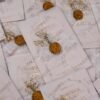 White vellum wrapped wedding invitations with organza ribbon and wax seals